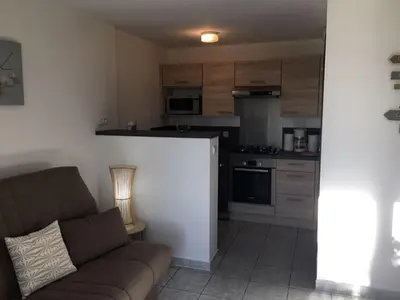 a living room with a couch and a kitchen at Gites Ugliastru PORTICCIO in Eccica-Suarella