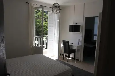 a bedroom with a bed and a desk and a window at 1er Consul SAS a Bussinca in Bocognano