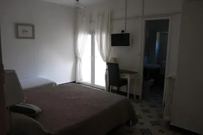 a hotel room with two beds and a desk and a window at 1er Consul SAS a Bussinca in Bocognano