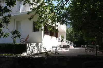 a white house with chairs and tables in front of it at 1er Consul SAS a Bussinca in Bocognano
