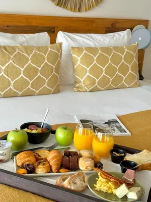 a tray of breakfast foods on a bed at Le Balamina in Porto-Vecchio