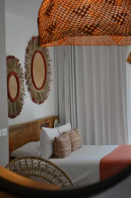a bedroom with a bed with pillows and a mirror at Le Balamina in Porto-Vecchio