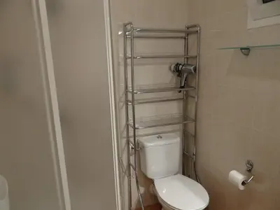 a bathroom with a toilet with a towel rack above it at Vue sur mer et montagnes in Moriani Plage