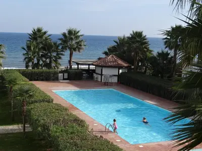 two people in a swimming pool with the ocean in the background at Vue sur mer et montagnes in Moriani Plage