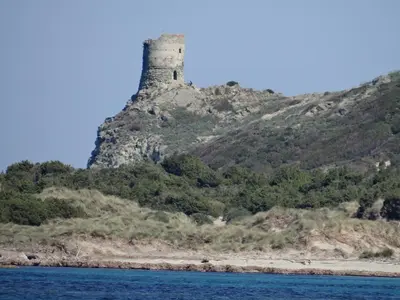 a castle on a hill next to the water at Vue sur mer et montagnes in Moriani Plage