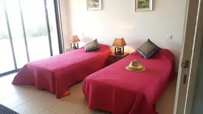 a room with two beds with pink sheets and a hat at Domaine les Hauts de Capicciola in Pinarellu