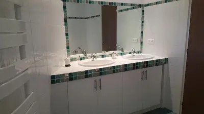 a bathroom with two sinks and a mirror at Domaine les Hauts de Capicciola in Pinarellu