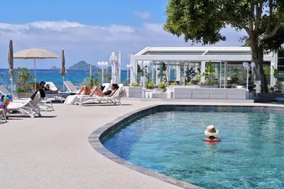 a swimming pool with a person in the water at Hôtel Restaurant Dolce Vita in Ajaccio