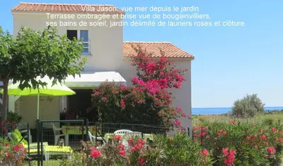 a house with pink flowers in the yard at Jason in Cervione