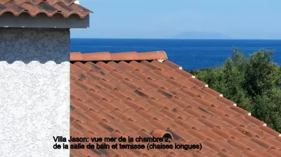 a red tile roof with the ocean in the background at Jason in Cervione