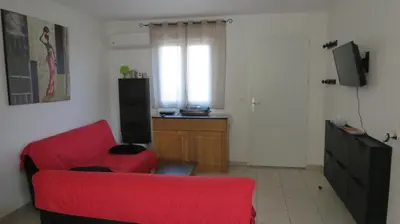 a living room with a red couch and a television at Jason in Cervione