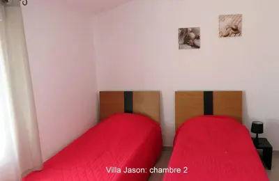 two beds in a room with red sheets at Jason in Cervione
