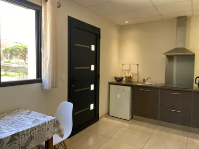 a kitchen with a black door and a table and a window at Casa Inde Noi in Corte