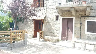 a building with a brown door and a wooden fence at les chalets montagne alta rocca in Zicavo
