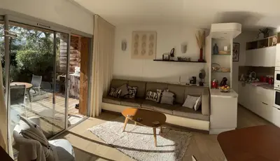 a living room with a couch and a table at Residence Cala Sultana -Baie Santa Giulia - rez jardin 1ere ligne in Porto-Vecchio