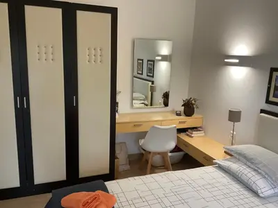 a bedroom with a bed and a desk and a mirror at Residence Cala Sultana -Baie Santa Giulia - rez jardin 1ere ligne in Porto-Vecchio