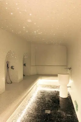 a bathroom with a toilet in the middle of a room at Grand Hôtel De Cala Rossa & Spa Nucca in Porto-Vecchio
