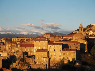 a group of buildings on a hill with mountains in the background at Belvedere de Sartène in Sartène