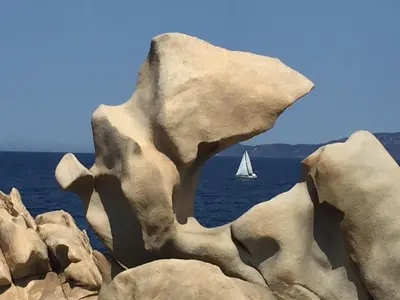 a sail boat in the water with rocks at Belvedere de Sartène in Sartène