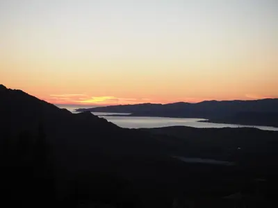 a sunset over a body of water with mountains at Belvedere de Sartène in Sartène