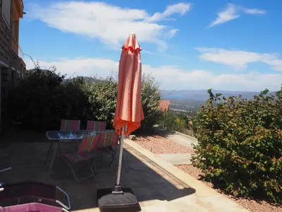 a red umbrella sitting on top of a patio at Belvedere de Sartène in Sartène
