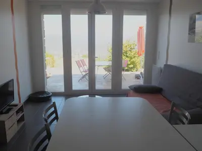 a living room with a table and chairs and a patio at Belvedere de Sartène in Sartène