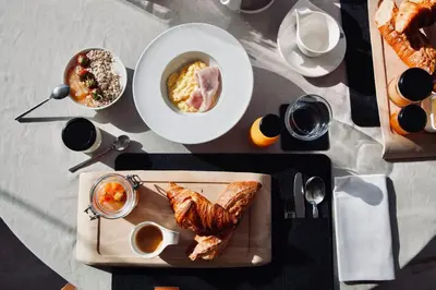 a table with a plate of food and a plate of bread at Auberge Kallisté - Eco Label in Porto Pollo