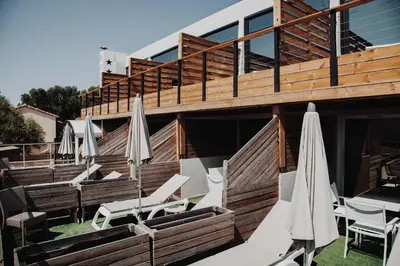 a group of chairs and umbrellas in front of a building at Auberge Kallisté - Eco Label in Porto Pollo