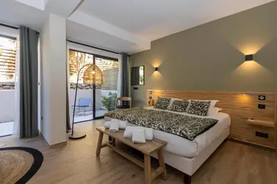a bedroom with a large bed and a large window at Auberge Kallisté - Eco Label in Porto Pollo