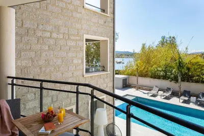 a house with a balcony with a swimming pool at Les Roches Blanches in Porto-Vecchio