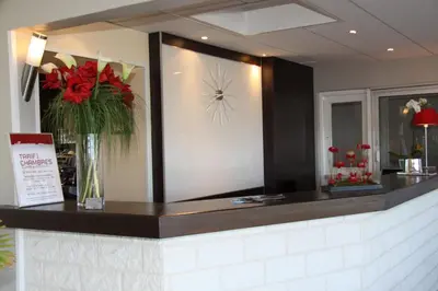 a counter with a mirror and a vase of flowers at Les Roches Blanches in Porto-Vecchio