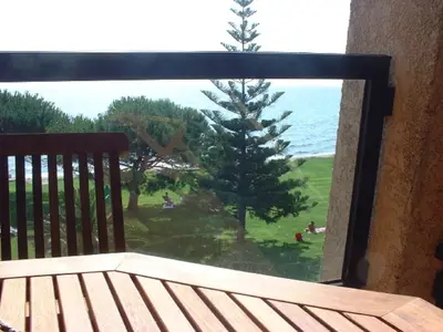 a view of the ocean from a balcony with a bench at Studio les pieds dans l'eau in Santa-Lucia-di-Moriani