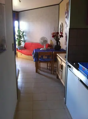 a living room with a red couch and a table at Studio les pieds dans l'eau in Santa-Lucia-di-Moriani