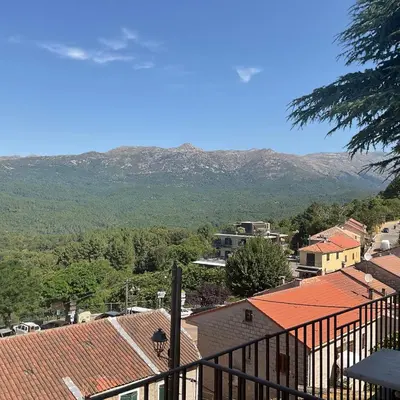 a view of a town with mountains in the background at Hotel La Terrasse in Zonza