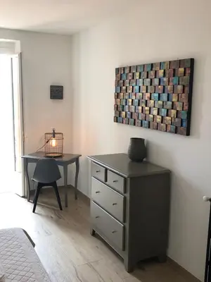 a bedroom with a desk and a table with a lamp at Hotel La Terrasse in Zonza