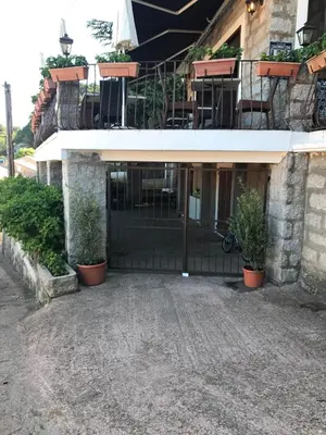 a front door of a building with potted plants at Hotel La Terrasse in Zonza