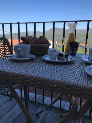 a table with coffee cups and a basket of bread at Hotel La Terrasse in Zonza