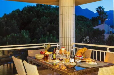 a table with food and wine on a balcony at Résidence Marina Bianca in Santa-Lucia-di-Moriani