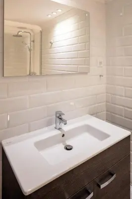 a bathroom with a white sink and a mirror at Résidence Marina Bianca in Santa-Lucia-di-Moriani