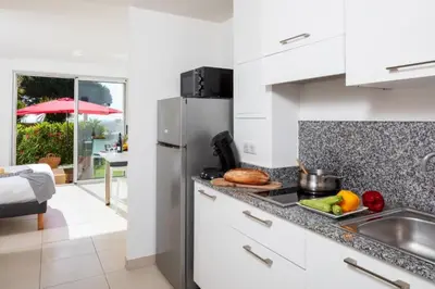 a kitchen with a sink and a refrigerator at Résidence Marina Bianca in Santa-Lucia-di-Moriani