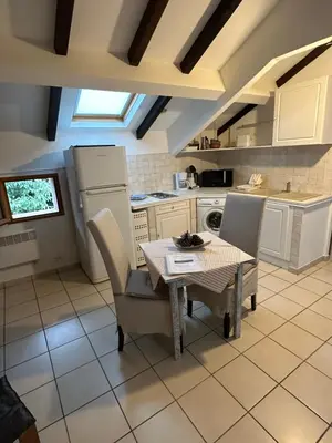 a kitchen with a table and chairs in a room at Studio Le Petit Nid d'Amour meublé Tourisme 3 étoiles Poggio in Santa-Lucia-di-Tallano