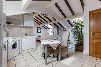 a kitchen and dining room with a table and a washing machine at Studio Le Petit Nid d'Amour meublé Tourisme 3 étoiles Poggio in Santa-Lucia-di-Tallano