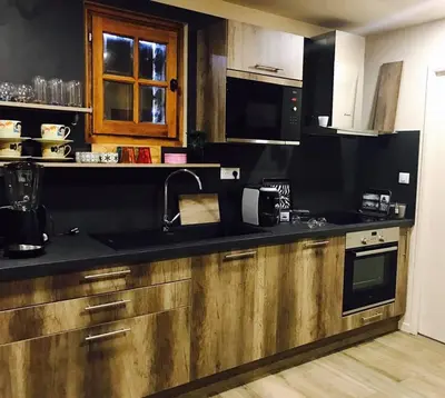 a kitchen with wooden cabinets and a black counter top at Residence Paradisu Ajaccio in Appietto