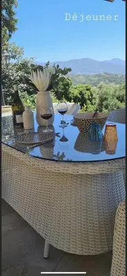 a table with wine glasses and wine bottles on it at Residence Paradisu Ajaccio in Appietto