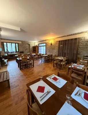 a dining room with wooden tables and chairs at Hôtel - Pub Le Petit Bosquet in Santo-Pietro-di-Venaco