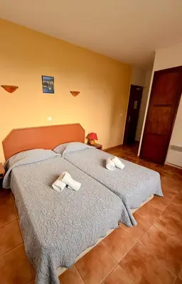 a bedroom with a bed with two towels on it at Hôtel - Pub Le Petit Bosquet in Santo-Pietro-di-Venaco