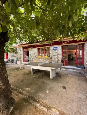 a ping pong table in front of a building at Hôtel - Pub Le Petit Bosquet in Santo-Pietro-di-Venaco
