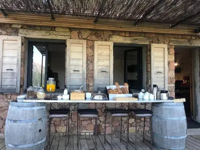 a kitchen with a counter with chairs and a sink at Casa Santa Lucia in Bocognano