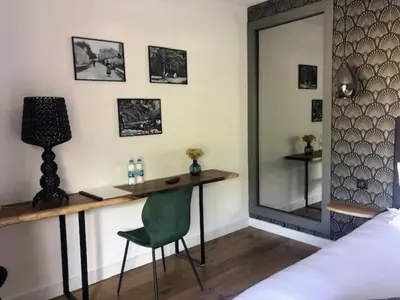 a bedroom with a desk and a green chair at Casa Santa Lucia in Bocognano