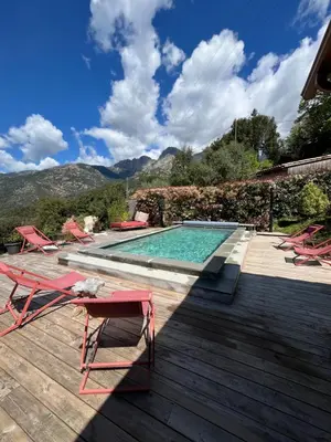 a swimming pool with a deck and chairs and a swimming pool at Casa Santa Lucia in Bocognano